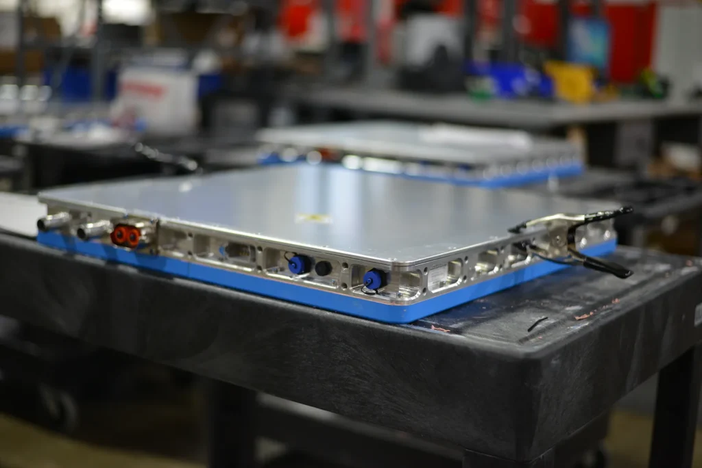 Close-up of a manual assembly build in progress at Kinetyc's manufacturing facility, featuring a metal component on a workbench.