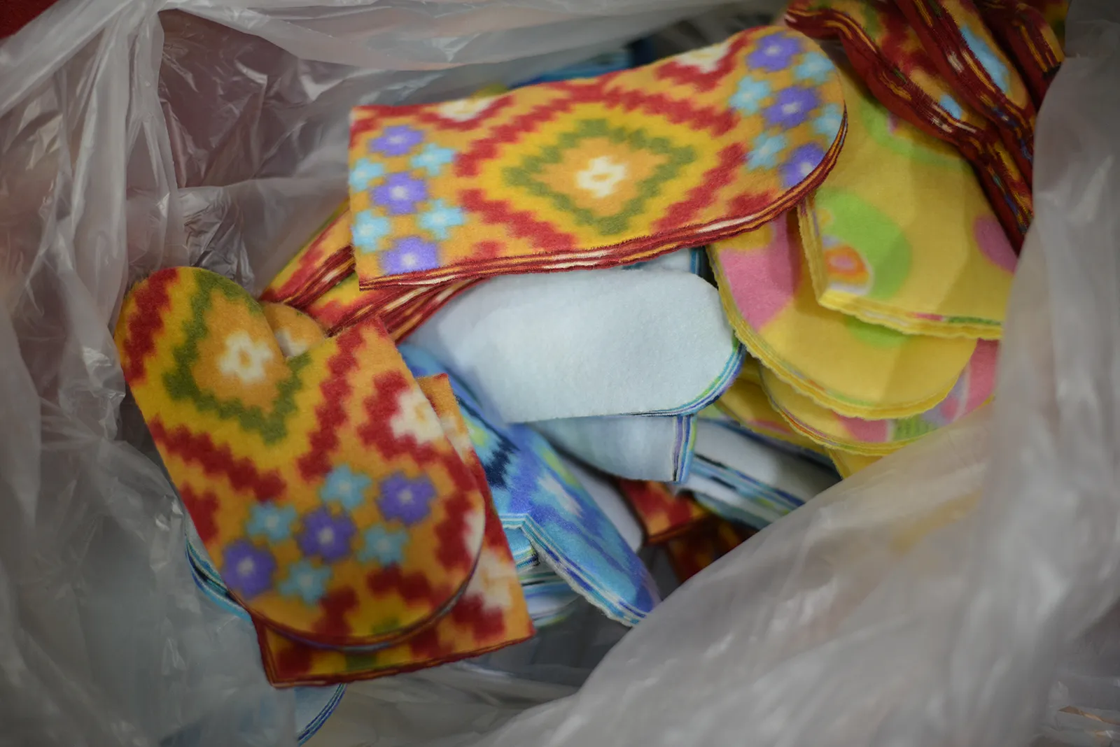 Stacked fleece fabric cutouts prepared for Fleece & Thank You blankets and stuffed animals, showcasing Kinetyc’s zero-waste adaptive manufacturing process.