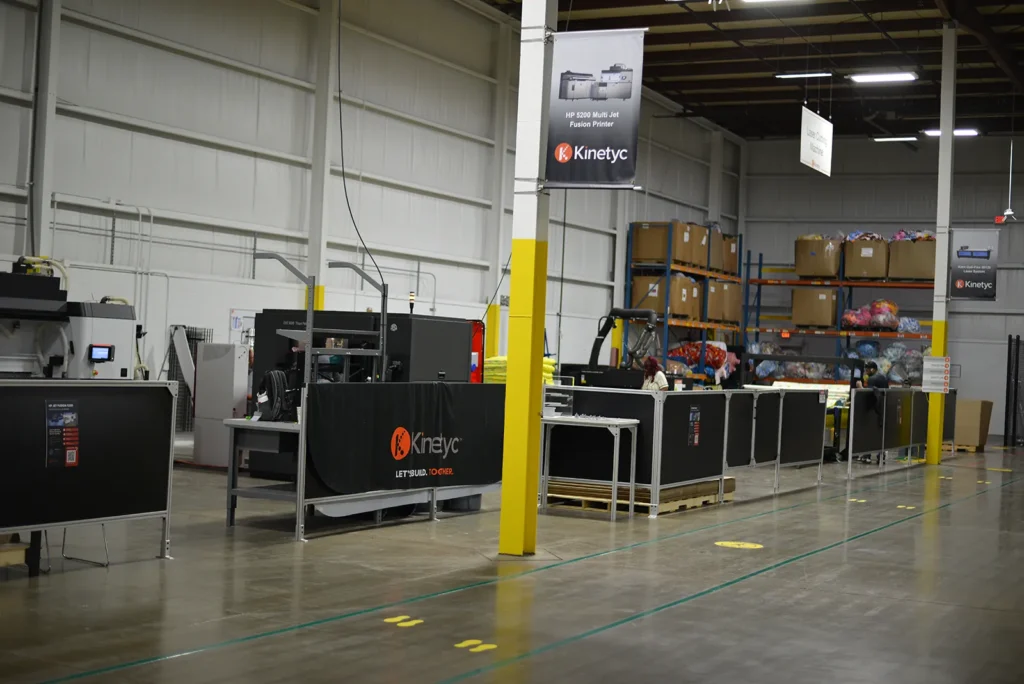 Wide view of Kinetyc’s technology center with additive manufacturing equipment and production workstations.