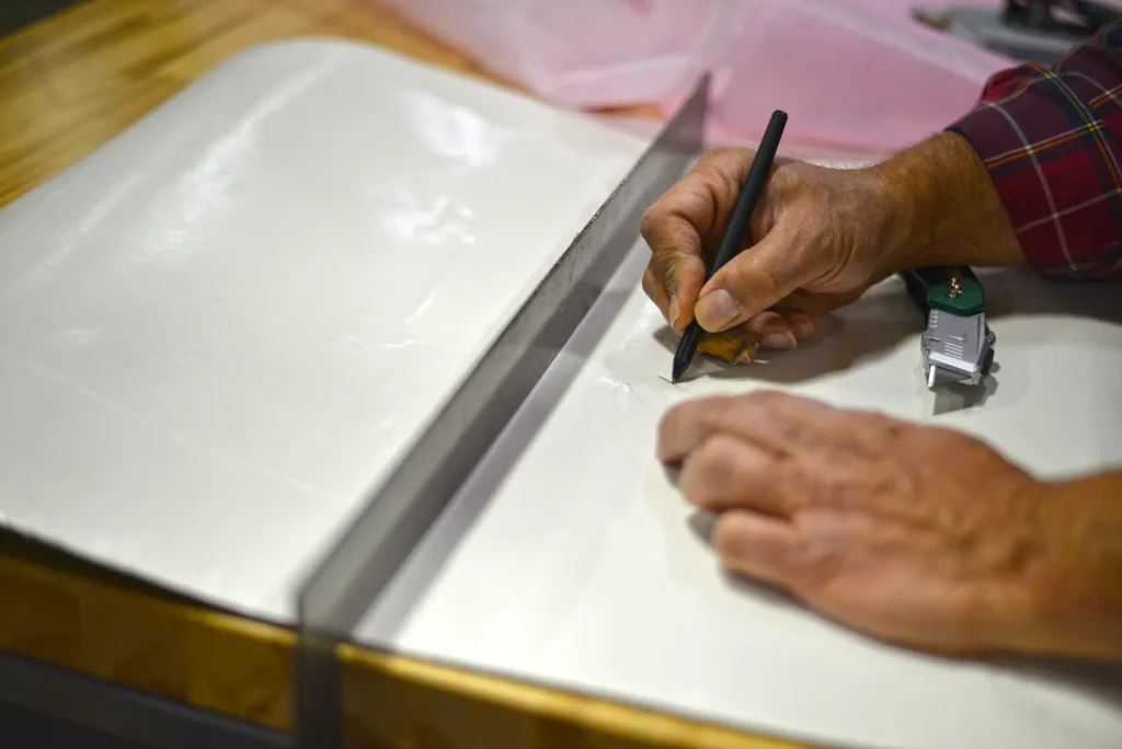 Manual cutting process during early-stage manufacturing before scalable production.