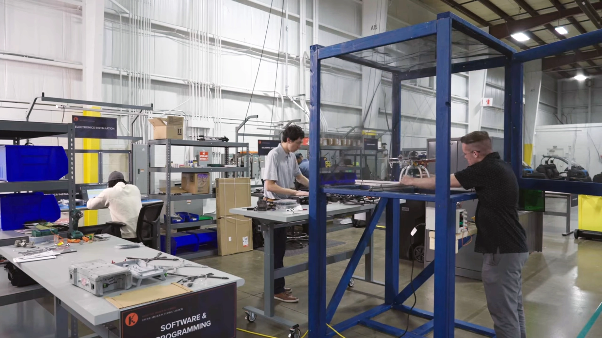 Technicians assembling and testing drone systems within a dedicated manufacturing cell at Kinetyc's Wixom facility.
