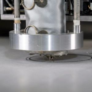 Close-up of Kinetyc's industrial laser cutting system cutting a circular shape into sheet material.