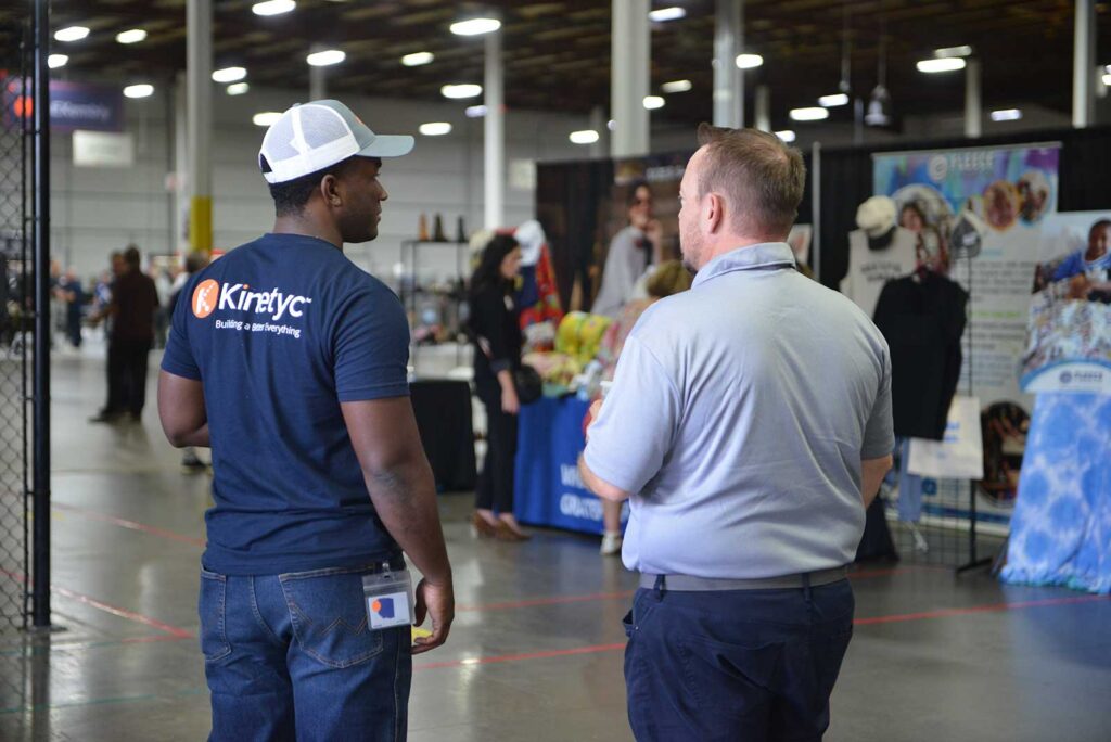 Kinetyc team member speaks with a guest during the 2026 Kinetyc Open House in Wixom, Michigan.