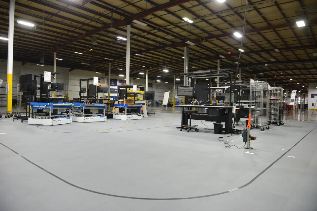 FLEXembly assembly workstations and material carts arranged on ESD flooring at Kinetyc.